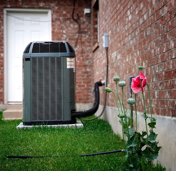 A home air conditioner sitting outside of the house.